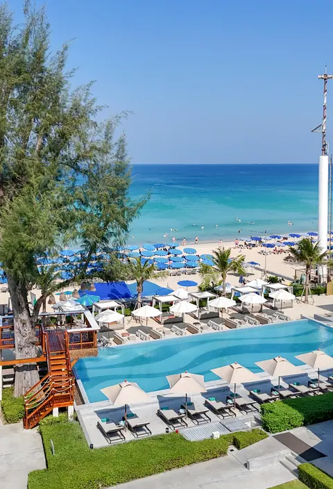 Beach club pool and loungers beside the sea