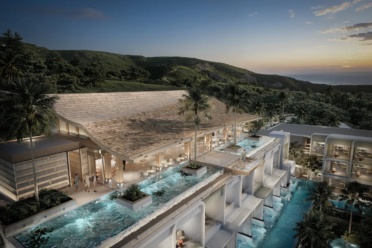 The resort from above at dusk, its terraced pools stepping down the hillside towards the sea