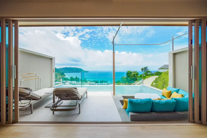 Seaview Sky Pool Villa at dusk, a glass-edged pool on the terrace framed by palms